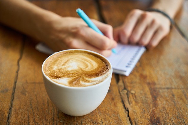 机の上のカフェオレとメモ帳